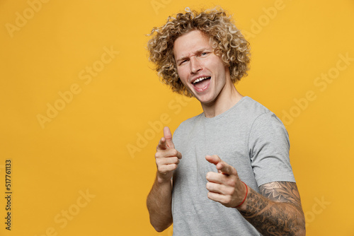 Young confident happy leader caucasian man 20s he wear grey t-shirt point index finger camera on you motivating encourage isolated on plain yellow backround studio portrait Fototapeta