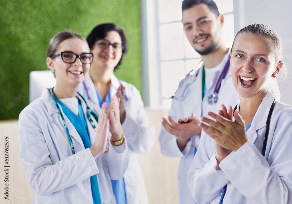 Happy medical team comprising male and female doctors smiling broadly and giving a thumbs up of success and hope Happy medical team comprising male and female doctors smiling broadly and giving a thumbs up of success and hope