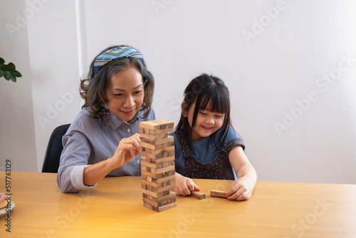 Grandmother and granddaughter play games. Blockwood Puzzle To develop skills for granddaughter and as a holiday activity photo