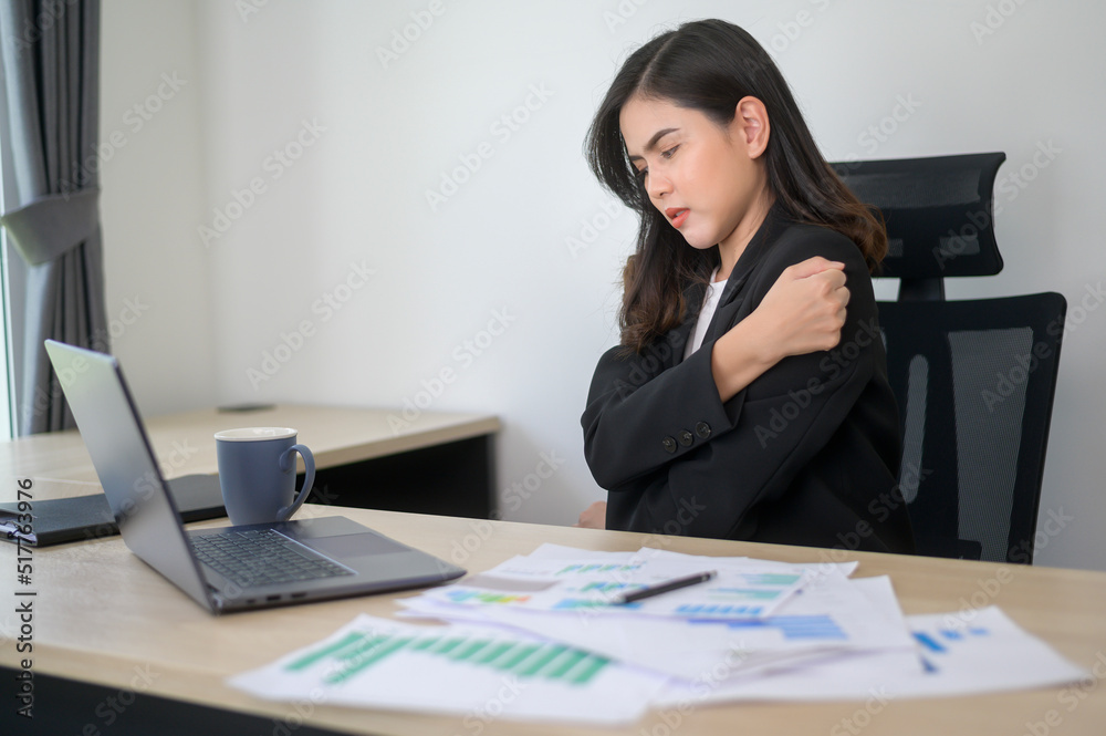 Stressed young business woman working on laptop with documents in modern office, workload concept Stressed young business woman working on laptop with documents in modern office, workload concept