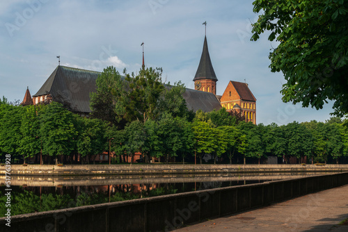 View of the Koningberg Cathedral on Immanuel Kant Island from the embankment of the Pregolya River on a sunny summer day, Kaliningrad, Russia photo