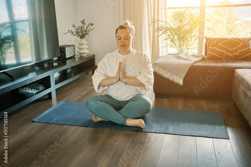 Woman doing online yoga at home. Female trener teaches asana in video conference. Health care, authenticity, sense of balance and calmness. 