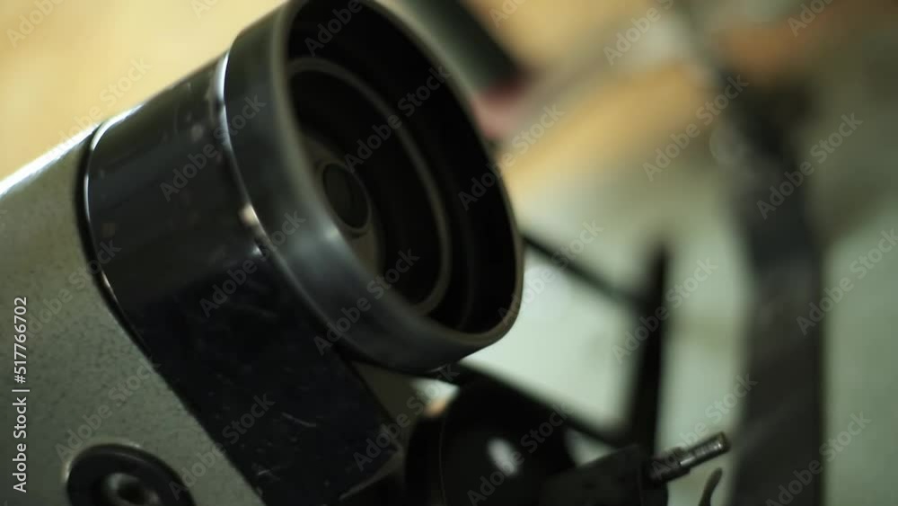 a ring with a belt is spinning on an automatic sewing machine, a hand is twisting the ring. men's hands are sewing clothes on a sewing machine. close-up a ring with a belt is spinning on an automatic sewing machine, a hand is twisting the ring. men's hands are sewing clothes on a sewing machine. close-up