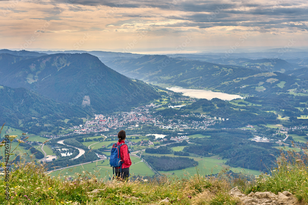 nice senior woman hiking at Mount Gruenten in the Allgaeu Alps with awesomw view over Iller valley to Lake Alpsee and Lake of Constanz, Bodensee,  Bavaria, Germany