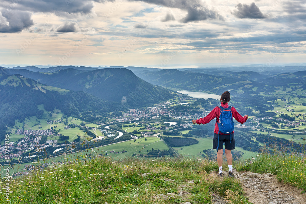 Naklejka premium nice senior woman hiking at Mount Gruenten in the Allgaeu Alps with awesomw view over Iller valley to Lake Alpsee and Lake of Constanz, Bodensee, Bavaria, Germany