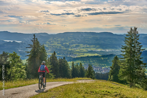 nice active senior woman riding her electric mountain bike at Mount Gruenten in the Allgaeu Alps , Bavaria, Germany