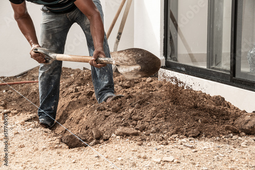 Man digging a hole in the ground with digging pick