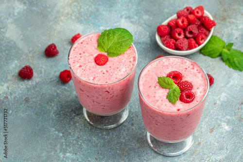 raspberries smoothie milkshake or yogurt in glass jar with berries. Yogurt cocktail on a blue background. place for text, top view photo