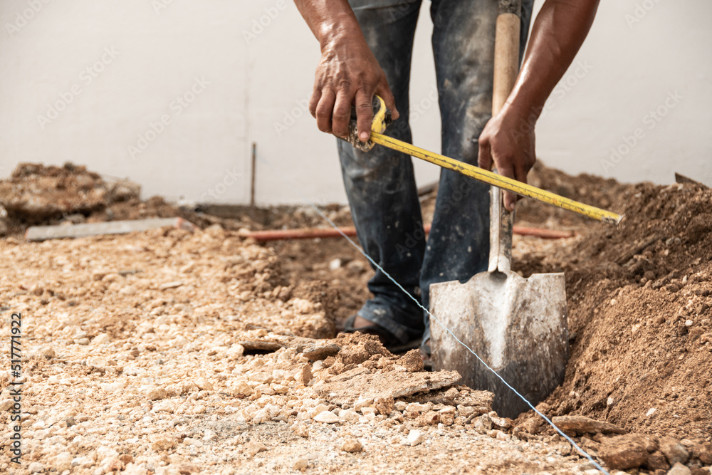 Man measuring and digging a hole in the ground with shovel Man measuring and digging a hole in the ground with shovel