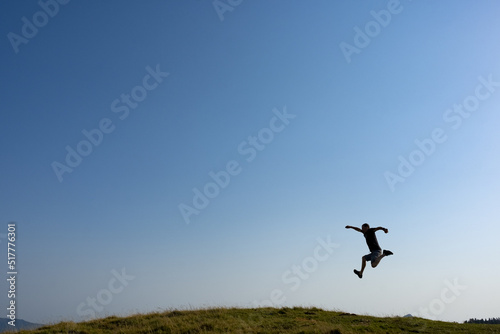 Hiker jumping on the mountain