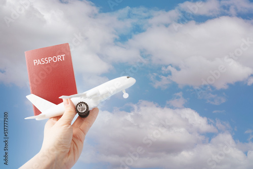 travel concept,tourism and vacation,holidays,air travel and airline tickets,airplane and passport in hand on sky background