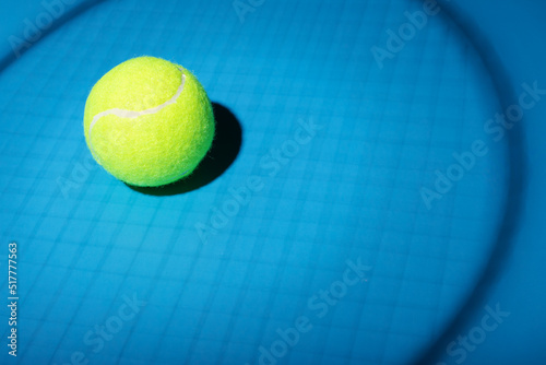 tennis ball in the shadow of a racket on a blue background, tenis sport © yta