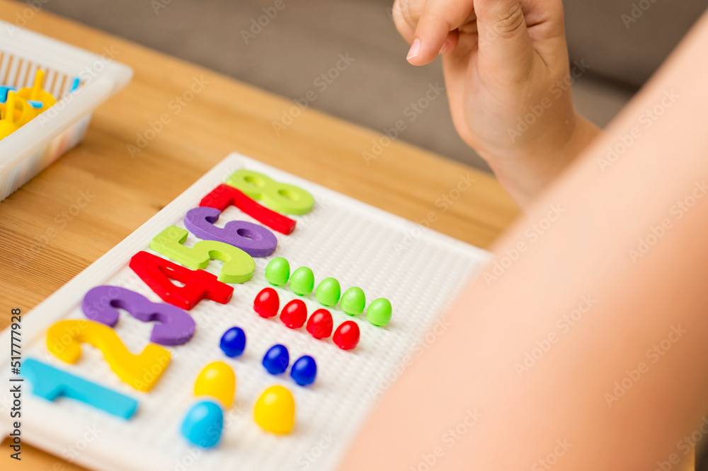 by provided numbers boy inserting pins. counting game. mathematical task. play at home. way of learning.