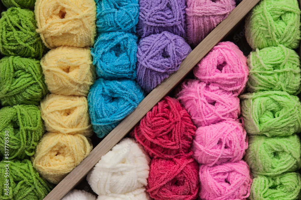 Lots of knitting threads, different colors and shades, stacked together