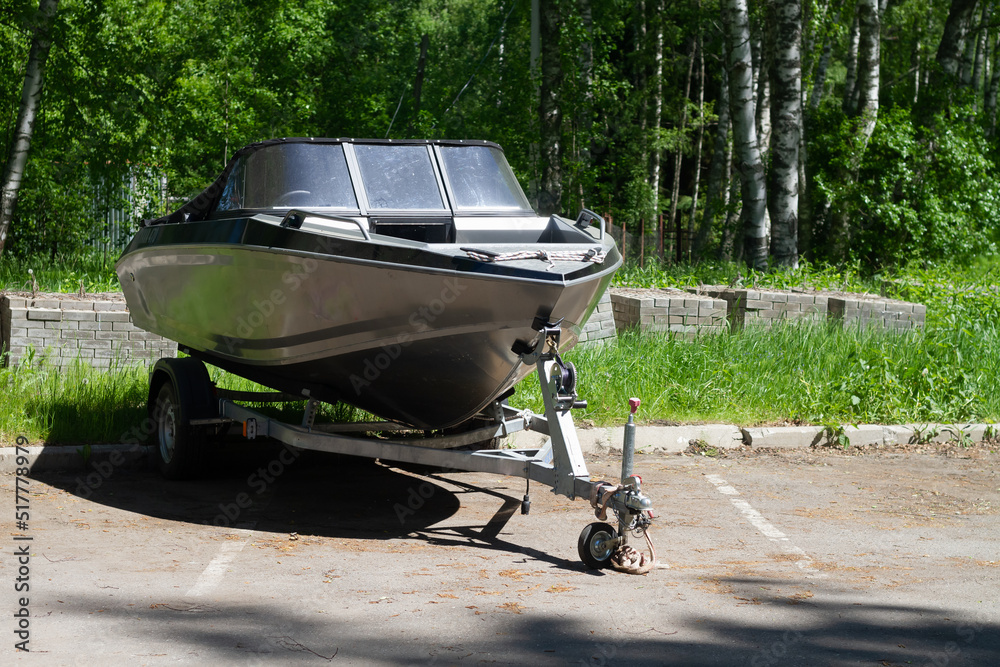 A boat or a boat with a motor on a trailer with wheels for transportation by car with a trailer