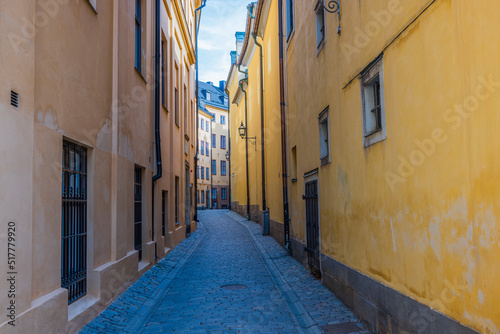 Beautiful view of narrow street between two yellow buildings. Sweden. Stockholm. © Alex