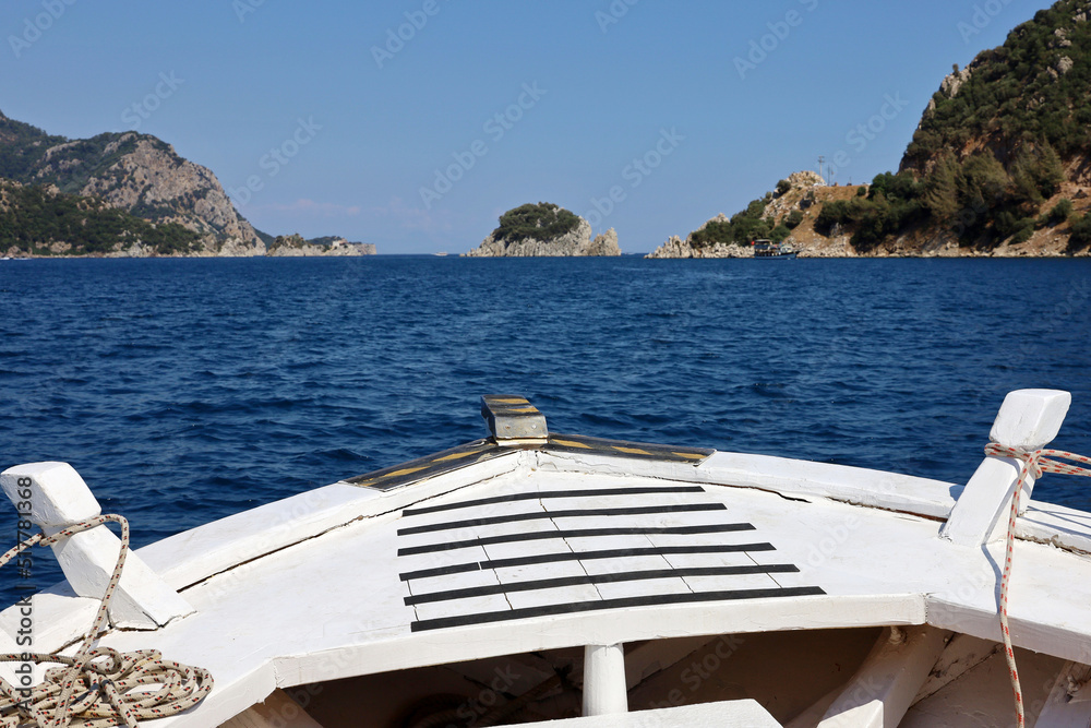 Obraz premium View from the bow of white wooden boat to Mediterranean sea with rock islands. Water travel, summer vacation