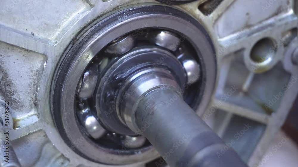 Astounding closeup of a spinning ball wheel with small taws fixed to a big cogwheel with teeth pulled by a metallic chain stripe in a technological and pro way