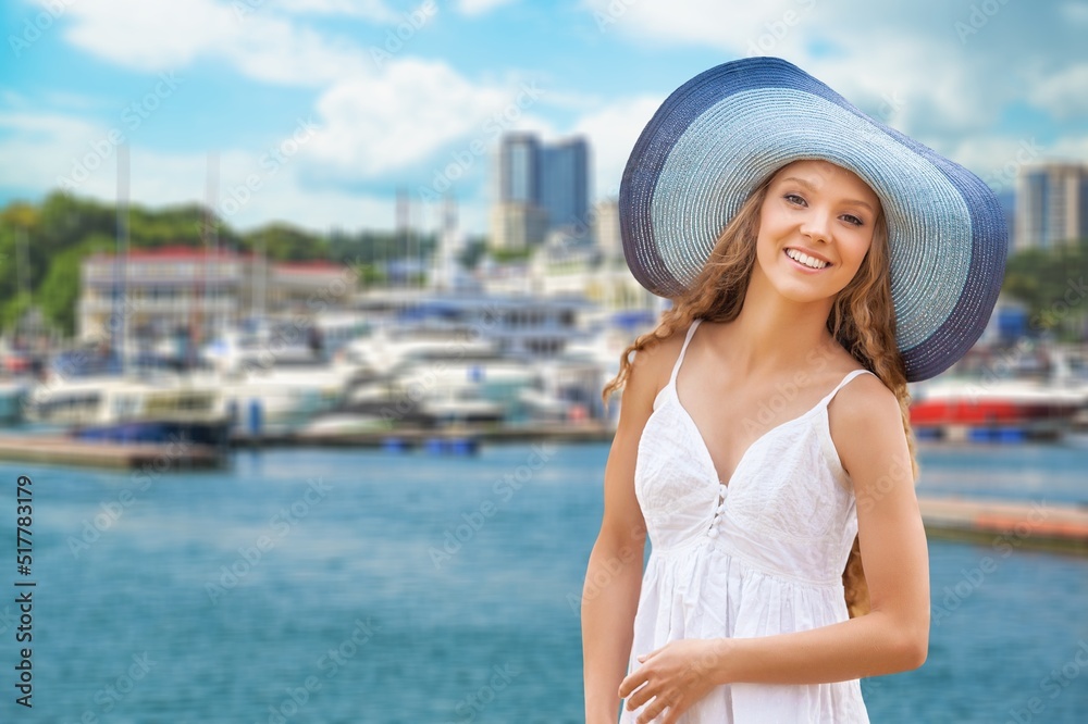Portrait of a woman wearing a hat enjoying the sun against the blue sea. Summer, vacation, vacation, active retirees