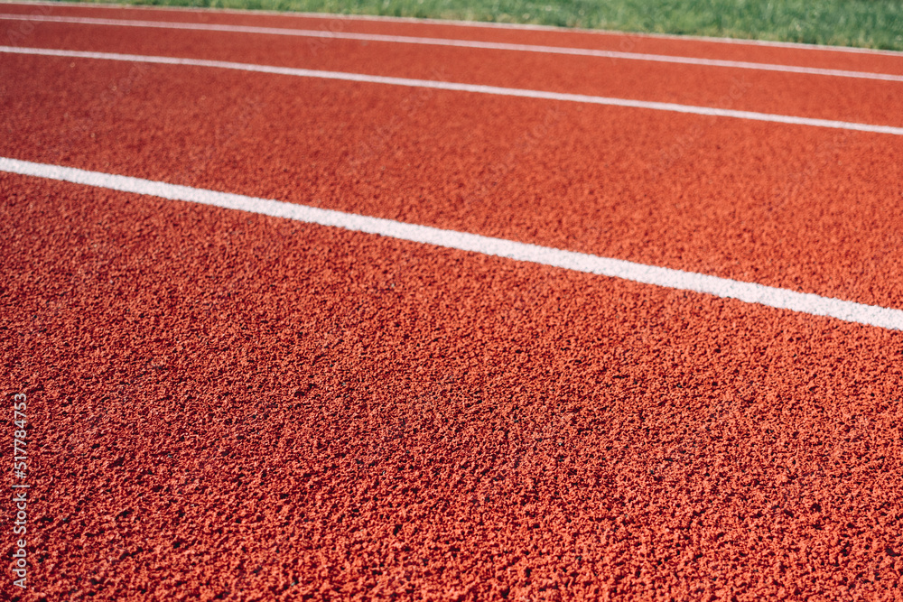 Sports stadium with red artificial rubber ground running tracks and white lines on it Sports stadium with red artificial rubber ground running tracks and white lines on it