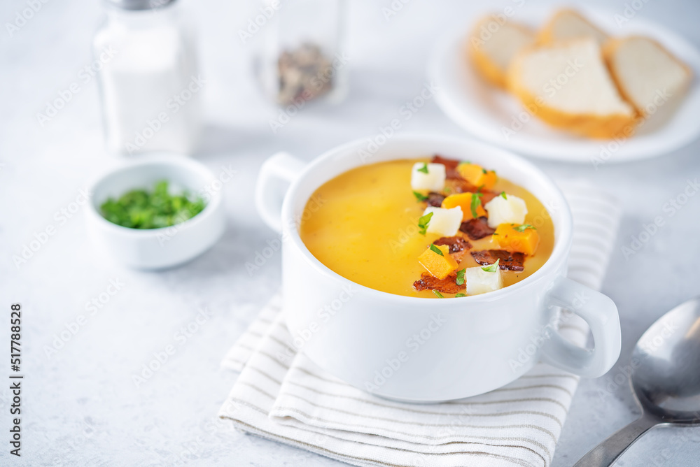Potato carrot soup with fried bacon slices in a bowl Potato carrot soup with fried bacon slices in a bowl