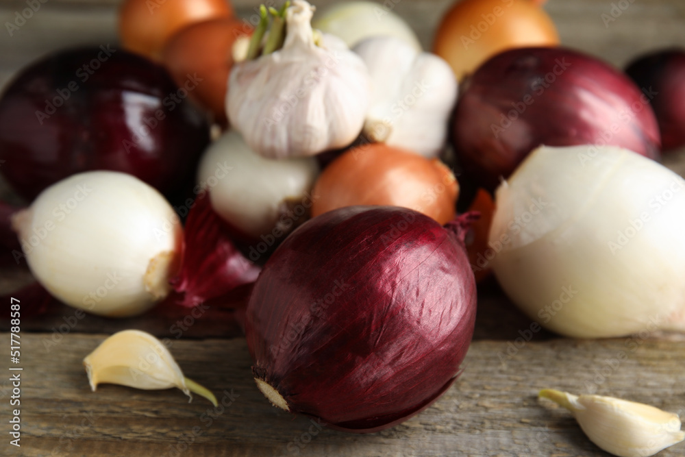 Fresh onion bulbs and garlic on wooden table, closeup Fresh onion bulbs and garlic on wooden table, closeup