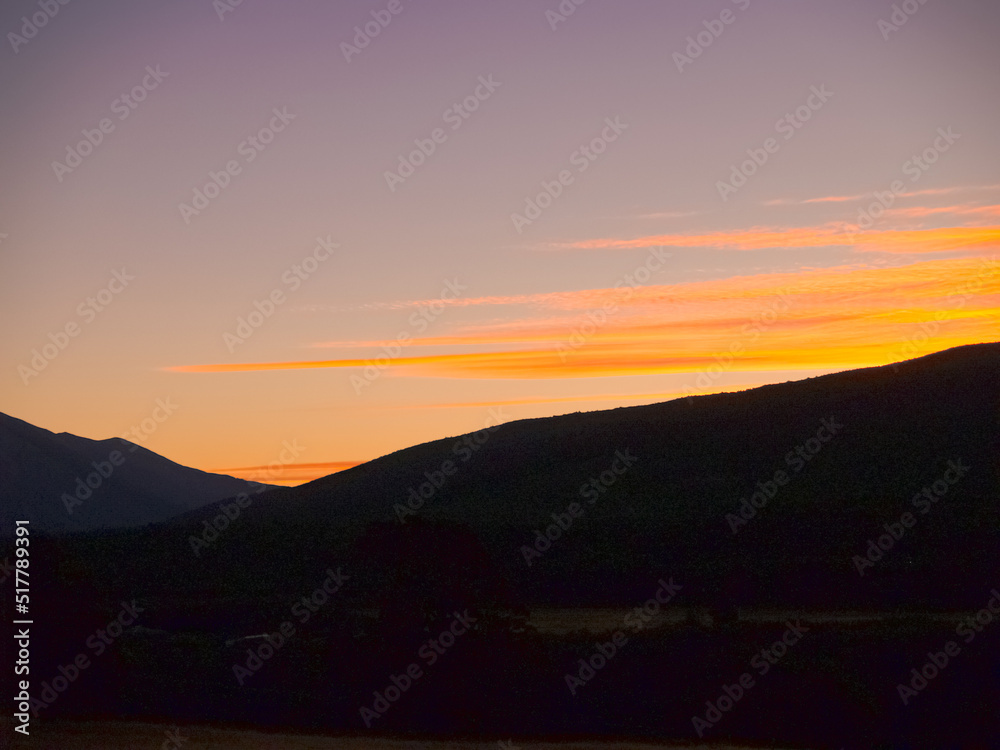 Colourful evening sky above mountain ridges in silhouette Colourful evening sky above mountain ridges in silhouette