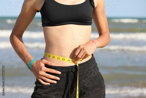 belly of the thin girl while measuring her waist with the measuring tape