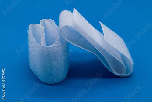 Foto Hook-and-loop fastener white Velcro in closeup on blue background