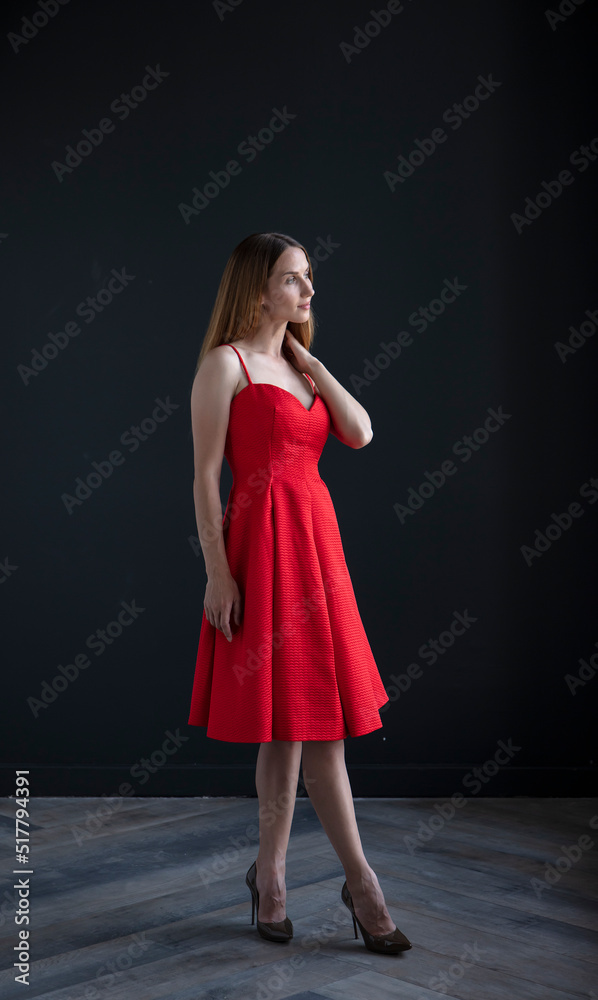 portrait of a young attractive woman on a dark background, full growth portrait of a young attractive woman on a dark background, full growth