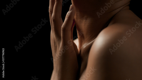 Big close-up shot of gorgeous fit African American woman strokes her clavicle on black background | Wrinkles prevention concept