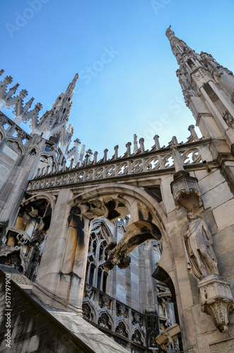 Gothic spires and white marble statues on Cathedral of Milan Duomo di Milano rooftop. Largest church in Italy and popular tourist attraction