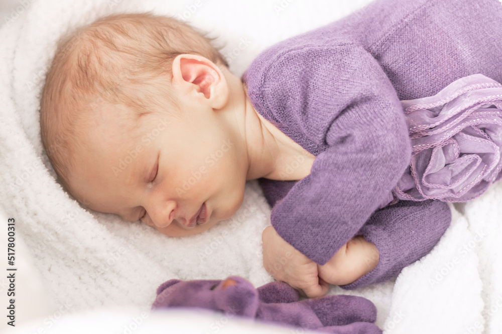 Cute newborn baby girl sleeps at home in her crib with her favorite toy, the first month of life Cute newborn baby girl sleeps at home in her crib with her favorite toy, the first month of life