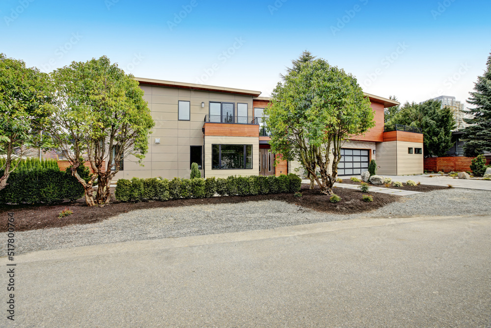Contemporary style home luxury home exterior with brown walls and dark framed metal windows. Green Northwest landscaping. Contemporary style home luxury home exterior with brown walls and dark framed metal windows. Green Northwest landscaping.