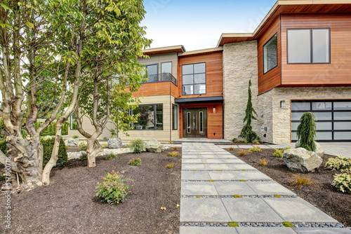 Contemporary style home luxury home exterior with brown walls and dark framed metal windows. Green Northwest landscaping.  © Iriana Shiyan