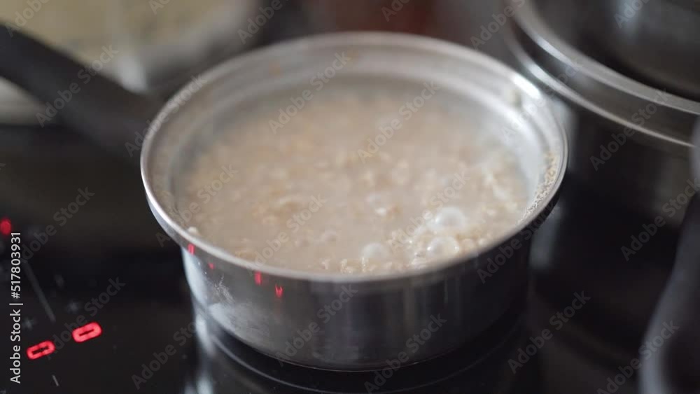 Healthy breakfast. A pot full of Porridge. Slow motion of a stainless steel ladle with boiling oatmeal on the stove. The concept of cooking. High quality FullHD footage Healthy breakfast. A pot full of Porridge. Slow motion of a stainless steel ladle with boiling oatmeal on the stove. The concept of cooking. High quality FullHD footage