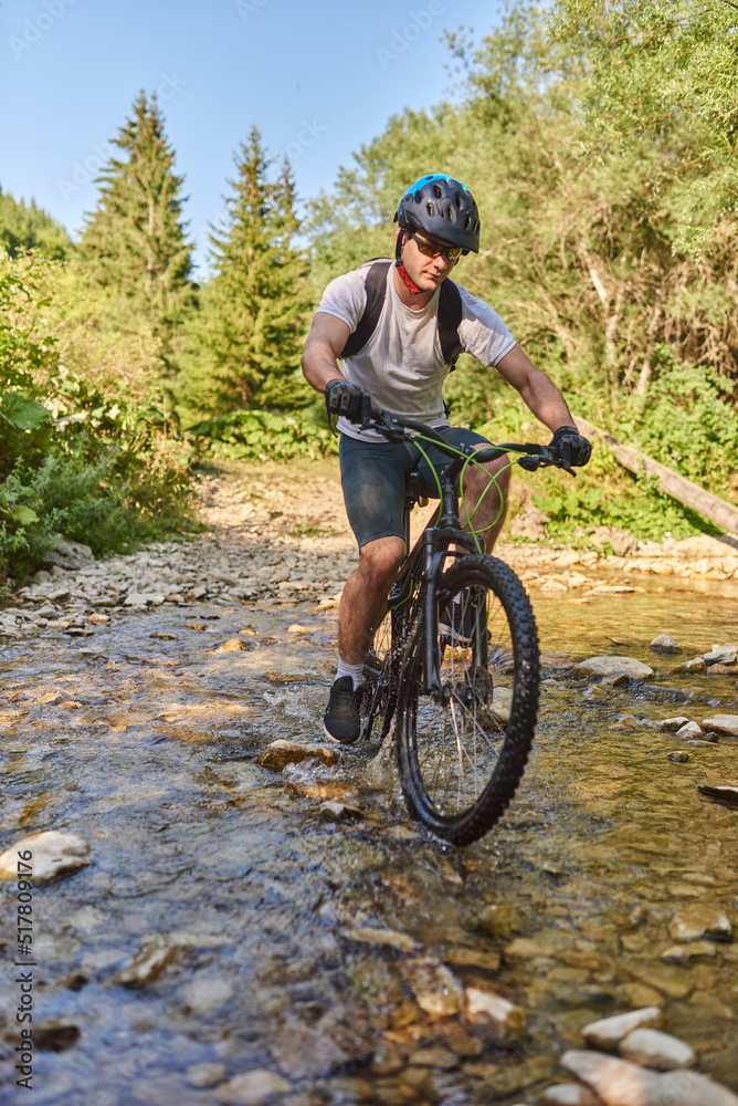 Fototapeta premium A cyclist rides a bike on extreme and dangerous forest roads. Selective focus
