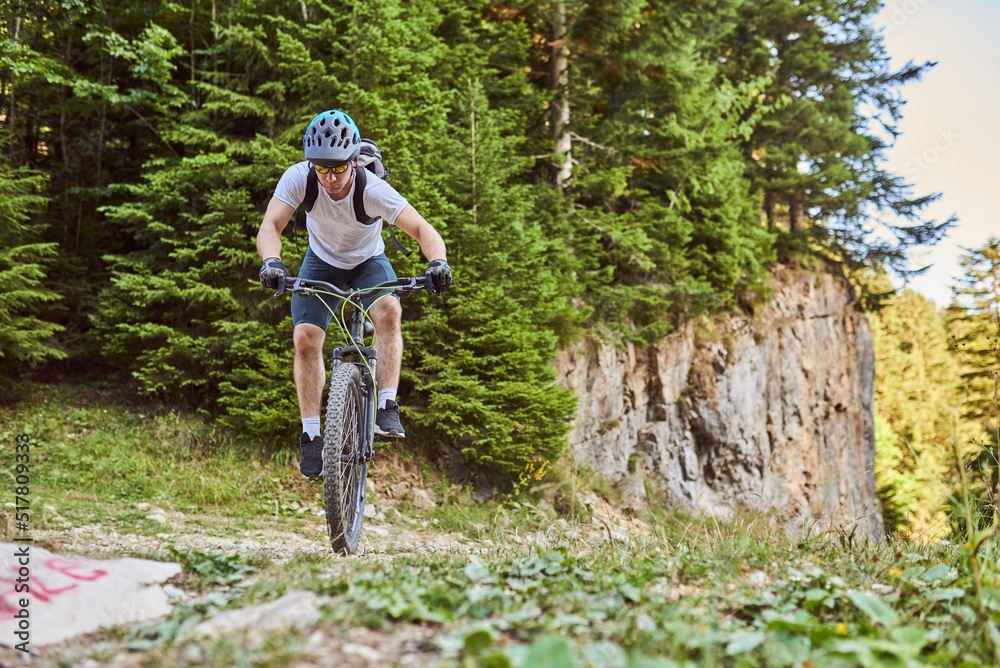 A cyclist rides a bike on extreme and dangerous forest roads. Selective focus