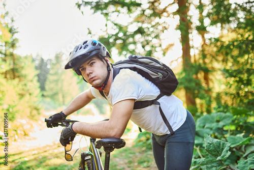 Cyclist resting after strenuous bike ride on forest roads