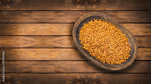 Fotografia Organic fenugreek seeds in the wooden bowl - Healthy food
