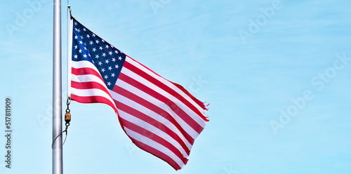 US American flag on pole against blue sky