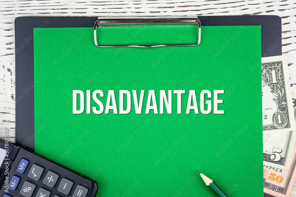 Obraz premium DISADVANTAGE - word (text) dollar bills on green background, pencil, calculator and wooden white table. Business concept: buying, selling, commerce (copy space).