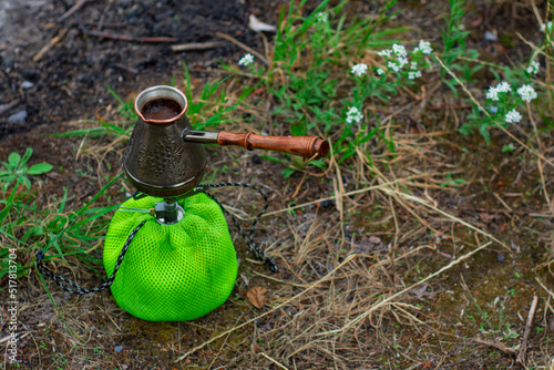 Tourist gas burner with a cezve for coffee against the backdrop of nature.