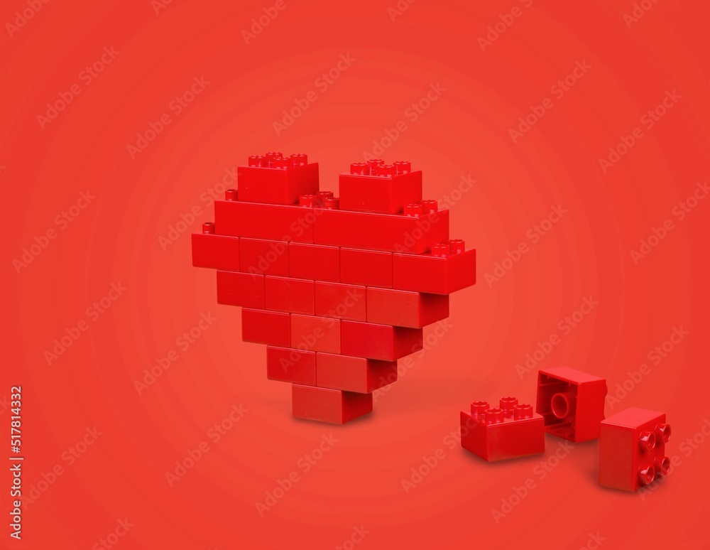 Fototapeta premium Red heart symbol made of plastic building blocks. Love symbol.
