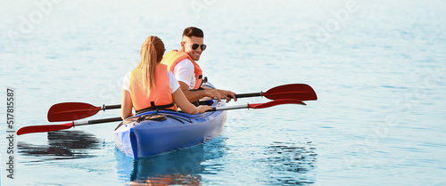 Young couple kayaking in ri...