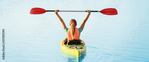 Young woman kayaking in riv...