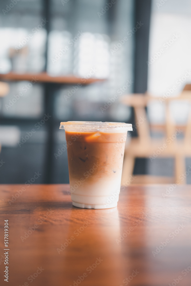Iced latte coffee, showing a layer milk and coffee in a plastic glass. Iced latte coffee, showing a layer milk and coffee in a plastic glass.