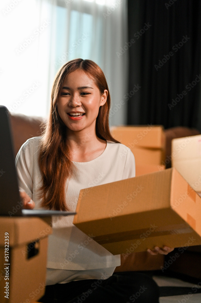 Female SME business owner preparing a shipping boxes in the living room. Female SME business owner preparing a shipping boxes in the living room.