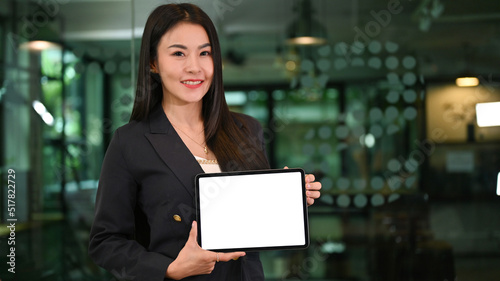 Beautiful Asian businesswoman holding a blank screen tablet mockup
