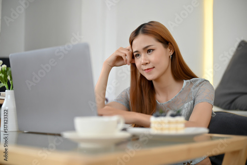 Beautiful young Asian female using laptop computer to research something Free Download Beautiful young Asian female using laptop computer to research something - GFXLoad